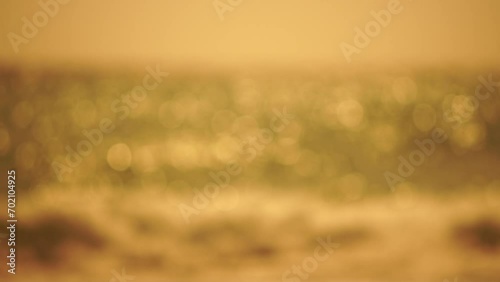 Blurred golden sea at sunset. The sun reflects and sparkles on the waves with bokeh, illuminating the golden sea. Holiday recreation concept. Abstract nautical summer ocean sunset nature background. photo