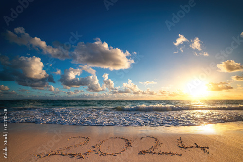 Fototapeta Naklejka Na Ścianę i Meble -  Island beach sea sunrise and text happy new year 2024 on the sand