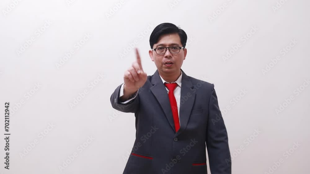 Asian businessman standing while making prohibition hands gesture Asian businessman standing while making prohibition hands gesture