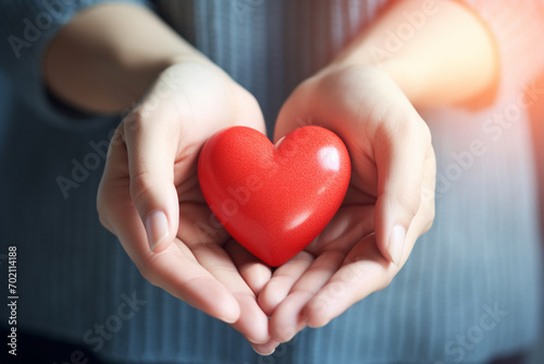 Red heart in the hands of a little girl. The concept of love and health. women s Woman s Day