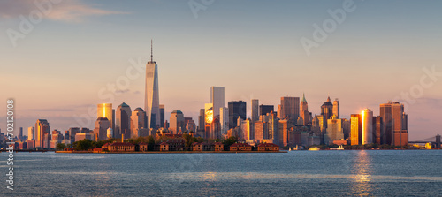 New York City Lower Manhattan skycrapers at sunset. Panoramic view from New York Harbor with the World Trade Center and Financial District buildings