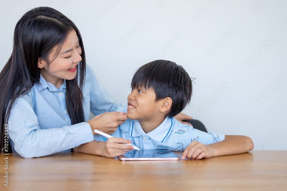 Teacher teaching kid boy student using digital tablet computer. Mother and her son use tablet computer. Woman teaching child son learning study tablet and doing homework. E-learning education concept. Teacher teaching kid boy student using digital tablet computer. Mother and her son use tablet computer. Woman teaching child son learning study tablet and doing homework. E-learning education concept.