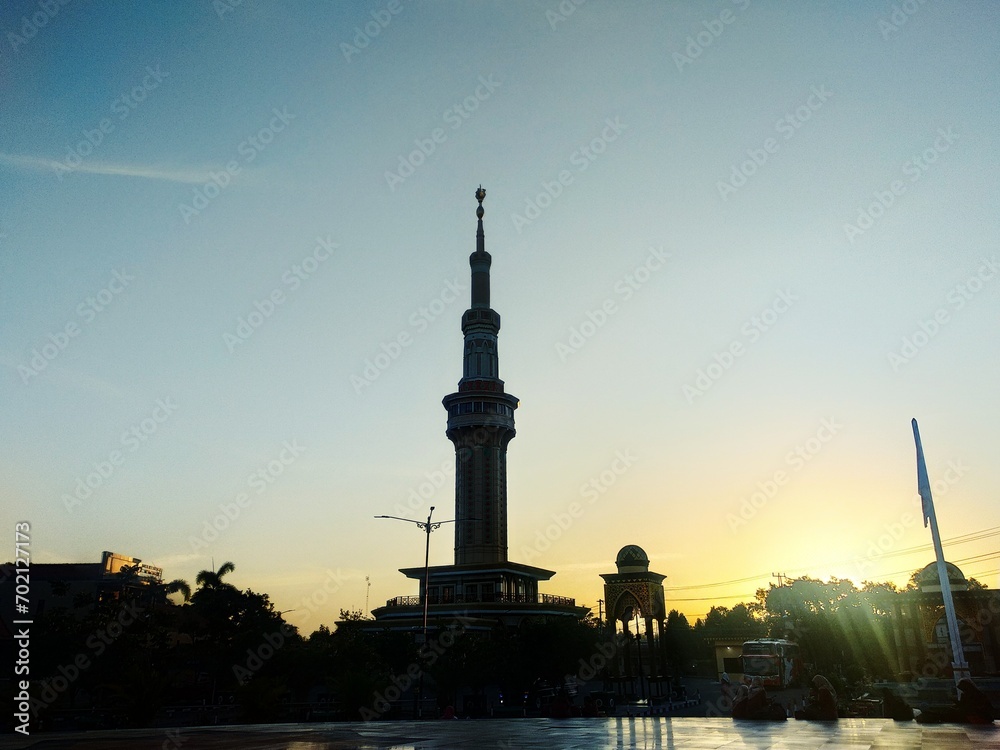 mosque with tall tower at sunset with blue sky 