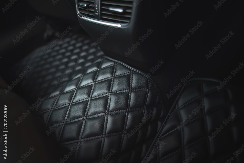 Premium luxury leather floor mat in a modern car interior. Auto service industry. Second row interior of a premium car with floor car mat. The modern, sophisticated and luxurious interior design. - obrazy, fototapety, plakaty 