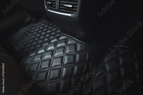 Premium luxury leather floor mat in a modern car interior. Auto service industry. Second row interior of a premium car with floor car mat. The modern, sophisticated and luxurious interior design. photo