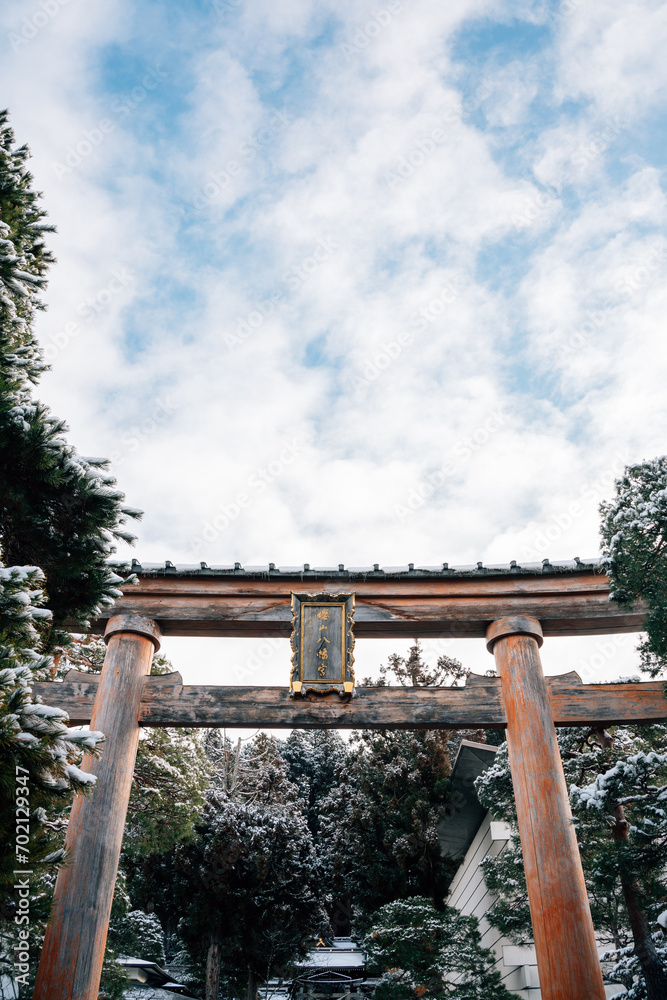 Sakurayama Hachimangu Shrine Torii gate and tree with winter snow in Takayama, Gifu, Japan