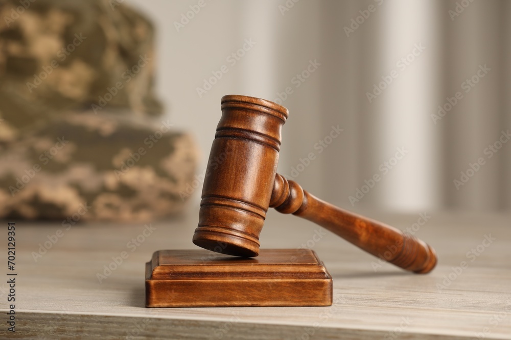 Law concept. Gavel and military uniform on wooden table, closeup Law concept. Gavel and military uniform on wooden table, closeup