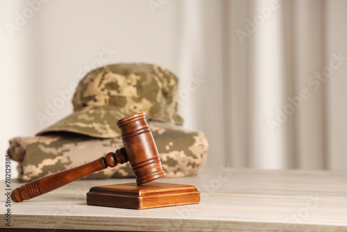 Law concept. Gavel and military uniform on wooden table, space for text