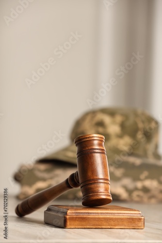 Law concept. Gavel and military uniform on wooden table, closeup. Space for text