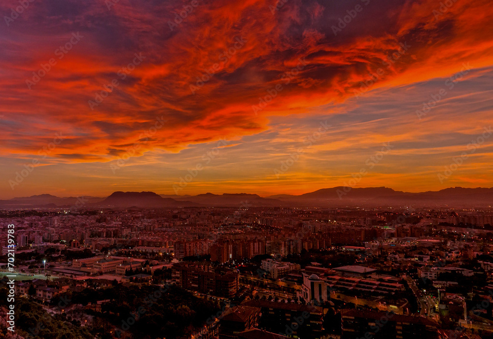 Cielo con enormes nubes de color rojo al atardecer sobre la ciudad de Alicante