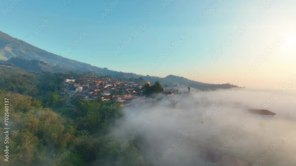 Aerial view, sea of mist in the mountains, forest in the morning of Nepal Van Java with colorful villages on the slopes of a volcano. Hillside countryside, Magelang, Indonesia Aerial view, sea of mist in the mountains, forest in the morning of Nepal Van Java with colorful villages on the slopes of a volcano. Hillside countryside, Magelang, Indonesia