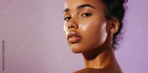 Portrait of young African woman with clean healthy facial skin on flat purple background with copy space. Natural beauty, care cosmetics banner template, perfect face skin. photo