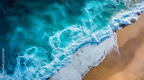 Aerial view of powerful waves on a sunny beach, summer travel.