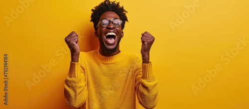 A happy young man raises his hands in elation Reaction after hearing good news. with copy space image. Place for adding text or design photo