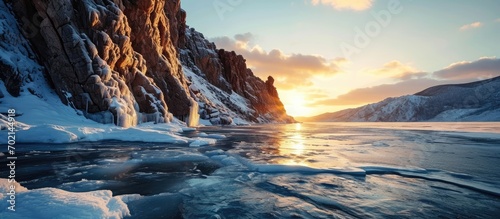 Beautiful winter landscape of frozen Lake Baikal at sunrise A granite rock with steep slopes rises above a frozen lake Baikal lake Siberia. with copy space image. Place for adding text or design