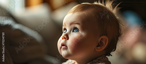 Closeup of thoughtful little baby girl looking away at home. with copy space image. Place for adding text or design
