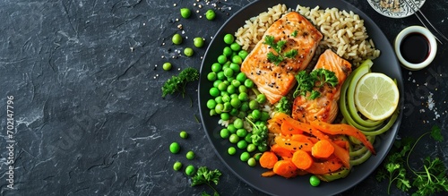 Fried salmon with brown rice peas carrots and leek on a plate. with copy space image. Place for adding text or design