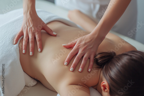 Close-up of a young woman receiving back massage in spa salon