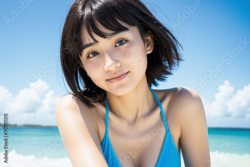 青空をバックに健康的に微笑む青いビキニ姿の若い日本人女性 © 佐咲 心菜