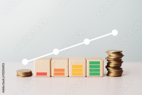 indicator with color levels on wooden cube and stack of coins. Measurement from poor to excellent rating for credit or mortgage loans concept photo
