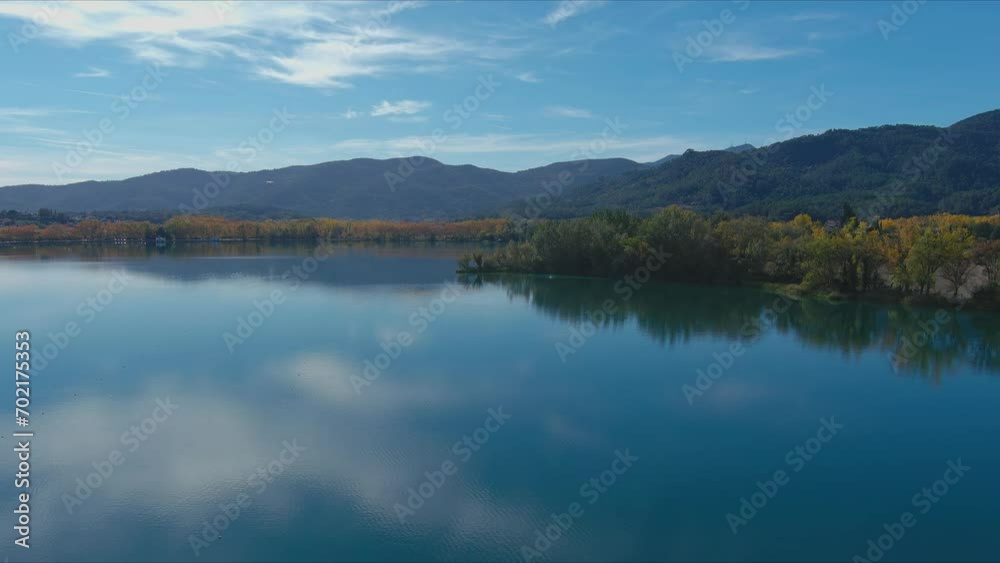 Lake Banyoles reflects sky and trees around it in autumn. Drone flight Lake Banyoles reflects sky and trees around it in autumn. Drone flight