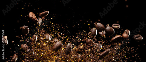 Coffee roasted bean ground fly explosion, Coffee crushed ground float pouring mix with beans. Roasted Coffee bean powder ground dust splash explosion in mid Air. Black background Isolated gold bokeh © Jade