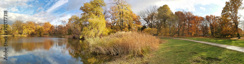 European park and pond in autumn. Atmospheric nature panorama photo.