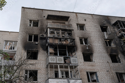 A multi-story residential building, heavily damaged after artillery shelling