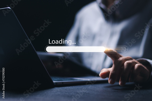 Businessman using laptop with loading bar on virtual screen to install or download software. progress bar, update, upgrade. photo