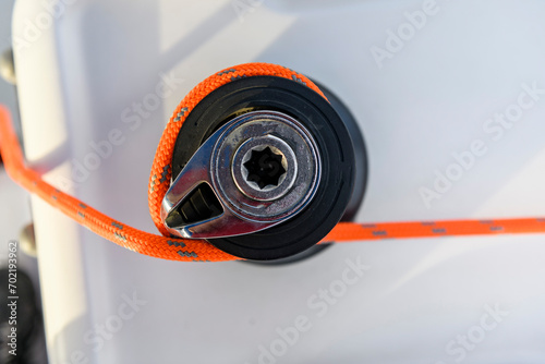 Yacht winch with orange rope on sailing boat. Top view. Yachting concept. photo
