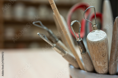 A set of tools for sculpting from clay in the workshop, at the workplace. Close up, place for inscription photo