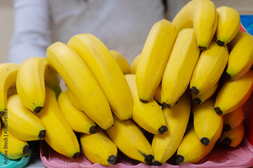 A stack of yellow ripe bananas on a store counter.
