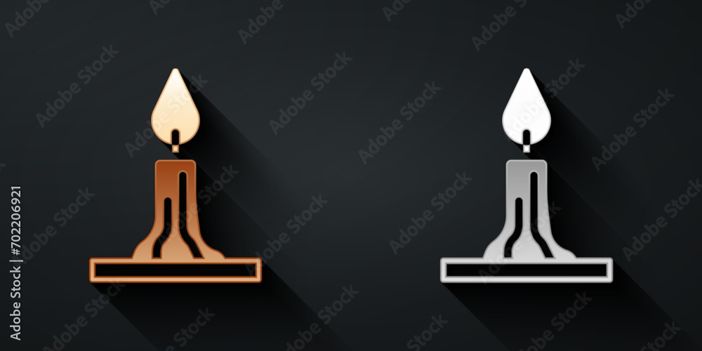Gold and silver Burning candle in candlestick icon isolated on black background. Cylindrical candle stick with burning flame. Long shadow style. Vector