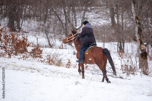 Horse rider gallops on a snowy mountain in Bakuriani