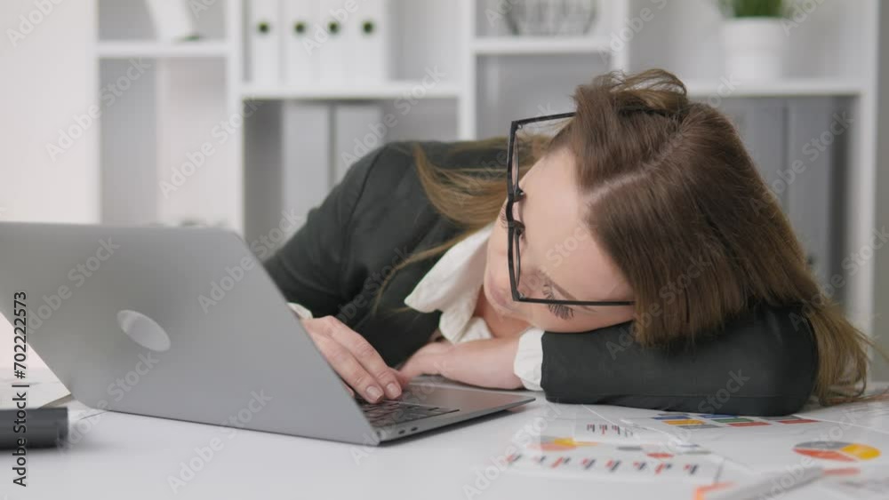 Tired businesswoman resting on desktop. Business woman fell asleep on table in front of computer. Fatigue, exhaustion, and overwork at work. Rest at the workplace and naps