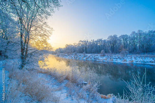 Enjoy the beauty of nature as the sun sets over the icy river. Witness the stunning hues of fiery orange and pink skies. Feel the warm glow of winter magic surrounding you.