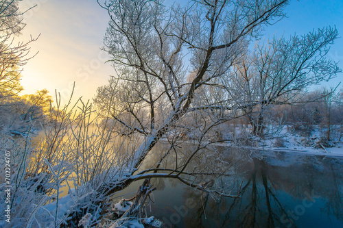 Experience the awe-inspiring beauty of nature's winter magic. Watch as the sun sets and colors the sky in fiery shades of orange and pink. See the warm glow of the sun reflected in the icy river.
