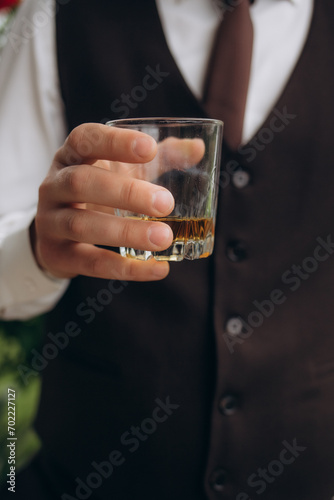 Businessman sitting and holding glass of whiskey