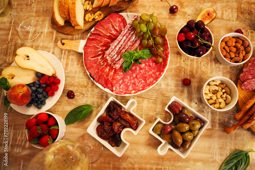 Dinner with snacks and wineglasses on table in living room