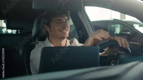 Carefree Caucasian driver man sit inside car turning on radio dancing enjoy sound music song dancing clap with hands on steering wheel drive rent auto road traffic modern computer device automobile photo