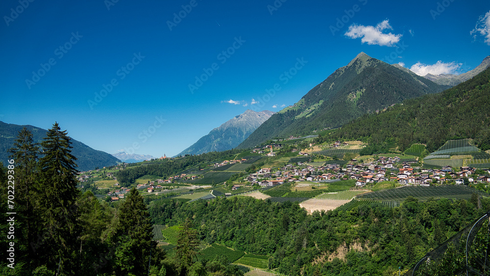 Panoramablick über ein Tal in Südtirol mit kleinen Ortschaften und Bergen im Hintergrund