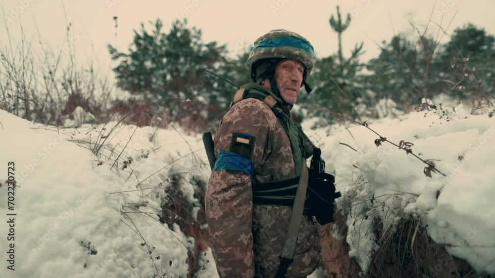 A soldier with a machine gun walks along the trench. A soldier in full armor walks along a trench. A soldier in the field. soldier with weapon in war. A soldier with a machine gun walks along the trench. A soldier in full armor walks along a trench. A soldier in the field. soldier with weapon in war.