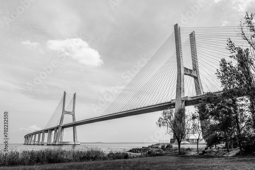 Vasco da Gama bridge in Lisbon, Portugal; cable stayed bridge flanked by viaducts and rangeviews that spans the Tagus river in Parque das Nacoes, the second longest bridge in Europe in black and white photo