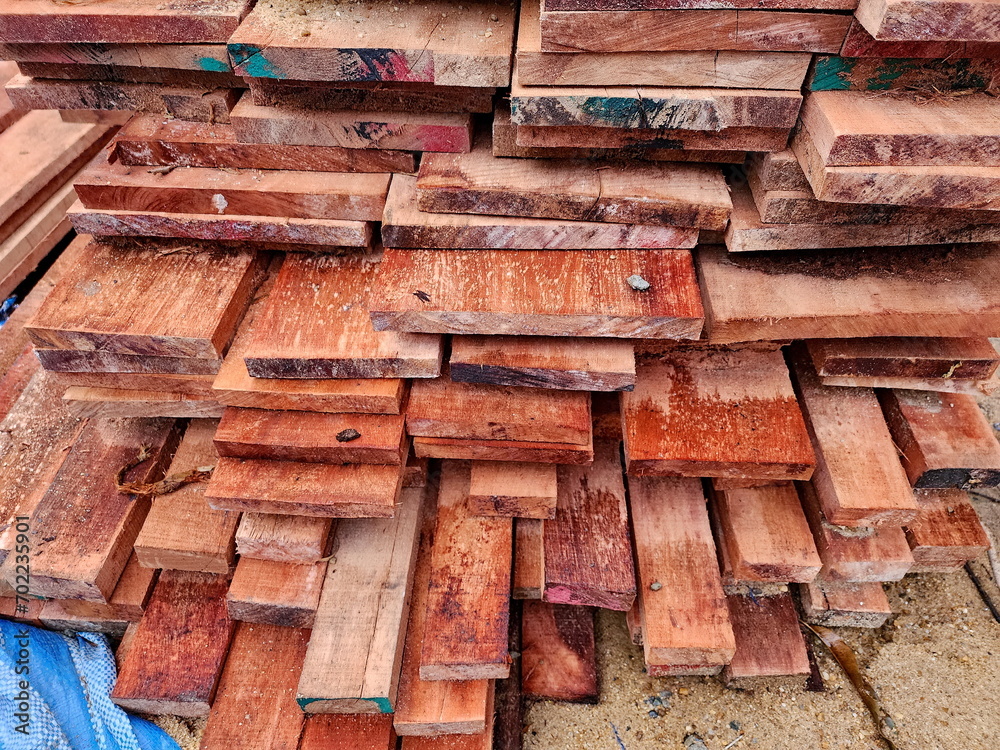 Hardwood lumber stacked in bulk on cement floor. To prepare temporary