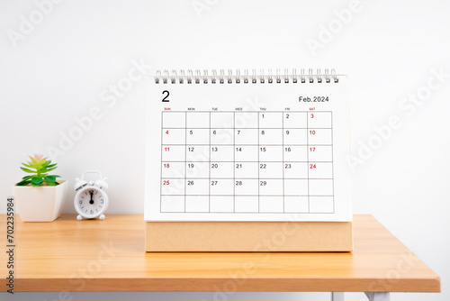 February Monthly desk calendar for 2024 year and alarm clock.
