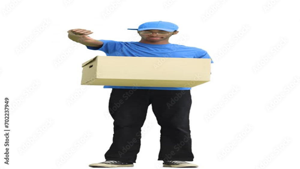 A male deliveryman, on a white background, full-length, with a box, shows his finger down A male deliveryman, on a white background, full-length, with a box, shows his finger down