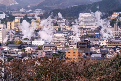 Beppu cityscape with Steam drifted from public hot spring  baths and ryokan onsen background, Beppu, Oita, Kyushu, Japan. © lukyeee_nuttawut