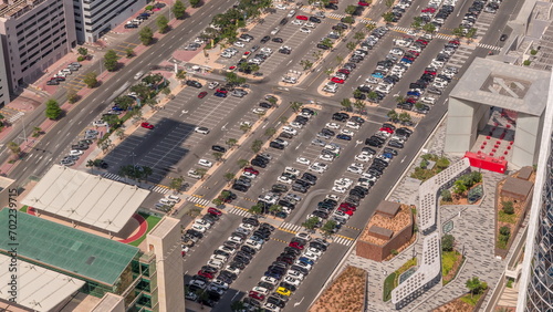 Aerial view of many colorful cars parked on parking lot with lines and markings for parking places all day timelapse. Dubai photo