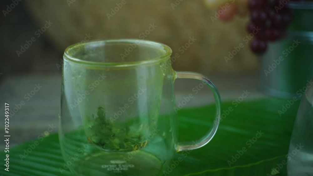 Pouring boiling hot water in glass teapot with fresh bay leaves. Healthy herbal drink from Indonesia. Pouring boiling hot water in glass teapot with fresh bay leaves. Healthy herbal drink from Indonesia.