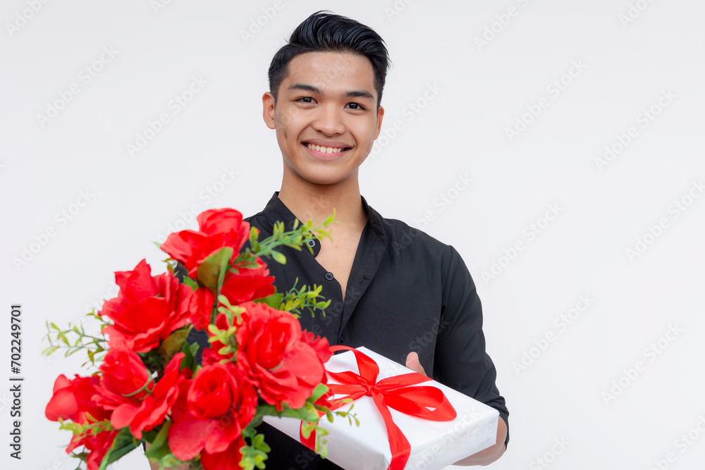 Portrait of a handsome male suitor handing flowers and gifts to a potential love interest during valentines or anniversary. Wearing black polo shirt, isolated on a white background. Portrait of a handsome male suitor handing flowers and gifts to a potential love interest during valentines or anniversary. Wearing black polo shirt, isolated on a white background.